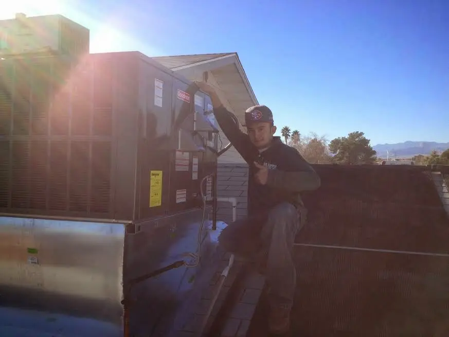 HVAC technician performing Heat Pump Repair on a rooftop unit in Streamwood